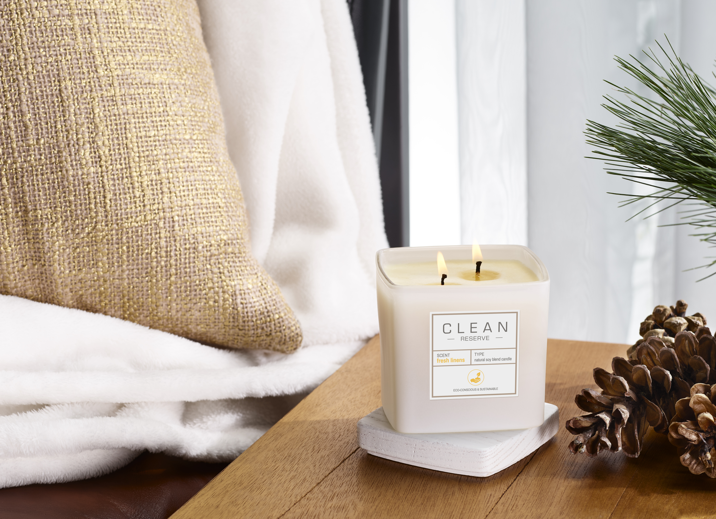 Clean reserve candle in fresh linens on bedside table
